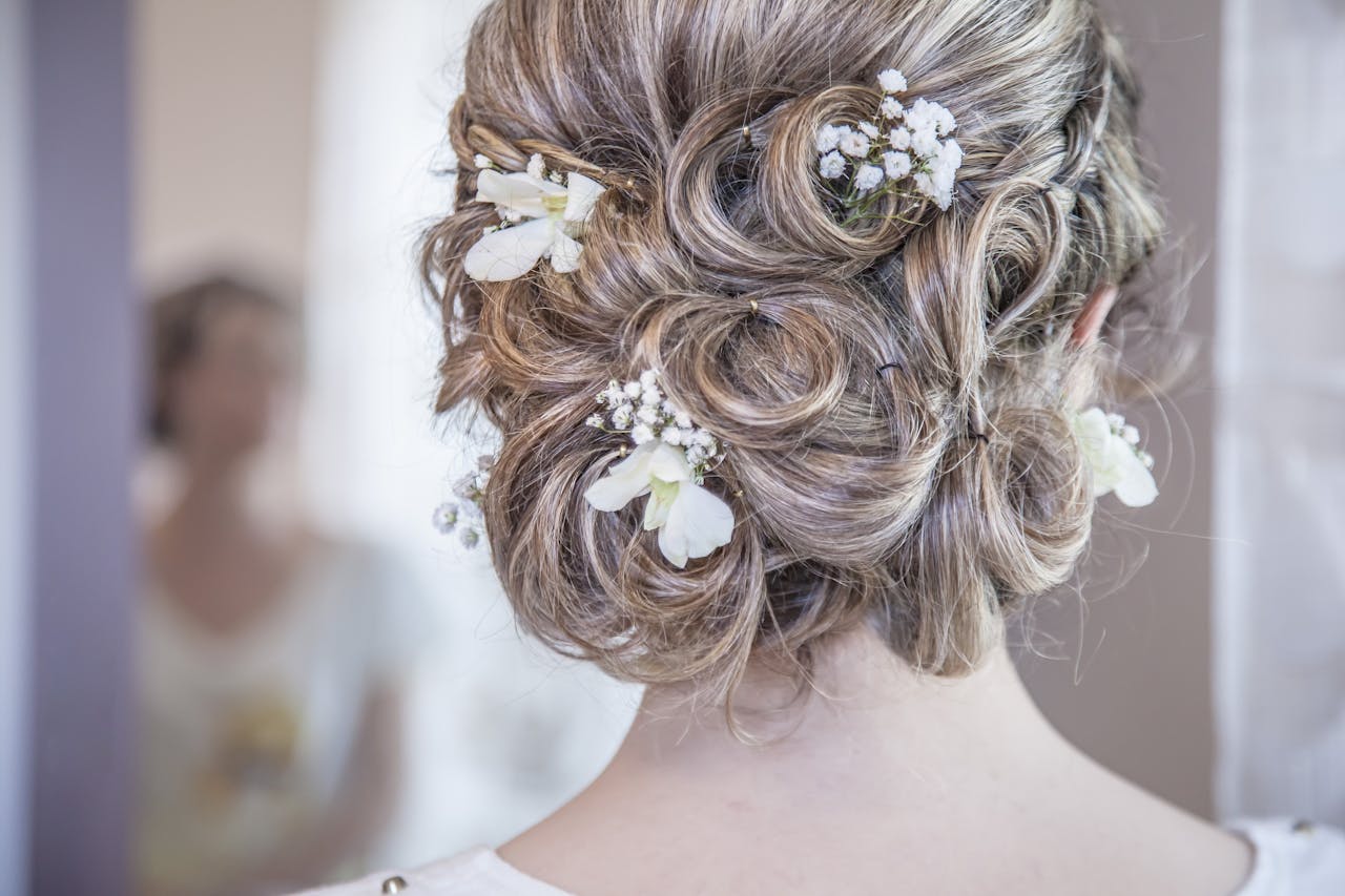 portfolio-01 Close-up of an elegant bridal hairstyle featuring delicate white flowers, perfect for a wedding day.